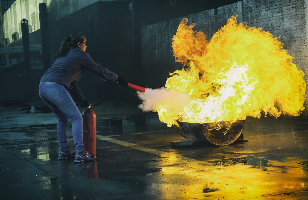 mujer evitando propagación de fuego con extintor