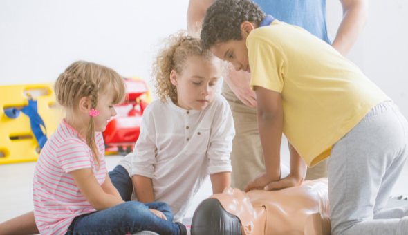 niños realizando primeros auxilios